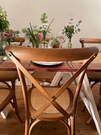 cross back chair and rattan seat with trestle table for hire